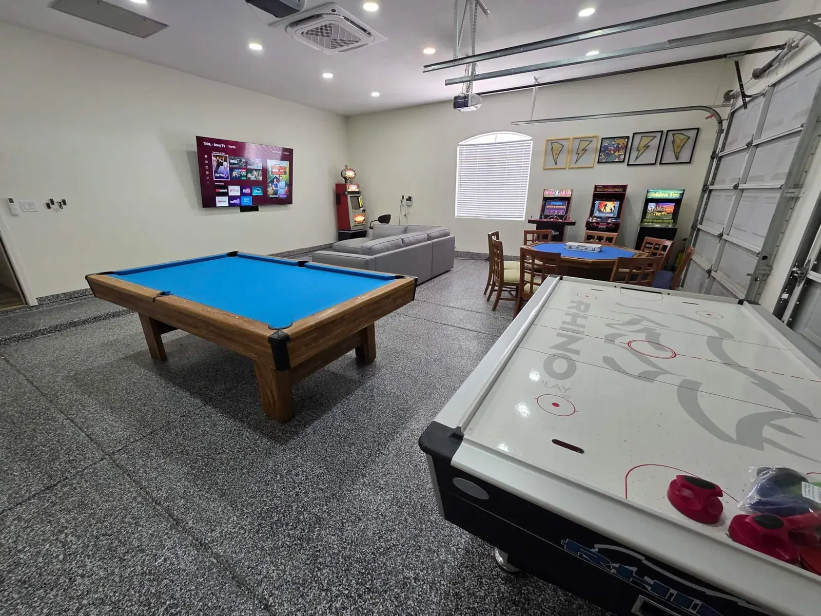 Game room with a professional pool table, air hockey, poker table and slot machines